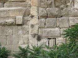 Large stones in a wall with a straight joint running vertically between masonry of two distinctive types