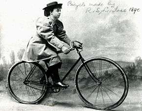 1800s photo of a woman on a man's bicycle