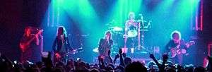 a color photograph of members of the group the Strokes performing on stage