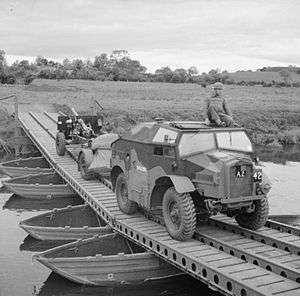 Photograph of a complete 25 pounder gun, limber and 'Quad' tractor crossing a bridge (in the British Isles)