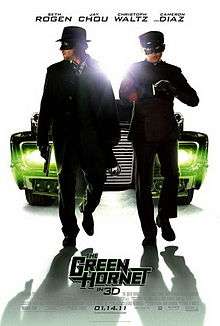 Two suited masked men, behind them is a large car behind them with green headlights, the film's title ,credits and release date below them while the cast names above.