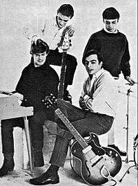 Four young white men posing with electric instruments