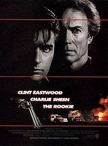 A black poster with three horizontal red lines. Above are the faces of two serious-looking men. The man on the left, is young and black-haired. The man on the right, is older and lighter-haired. The right sides of their faces are invisible because of darkness. Below that in bold white letters are the lines: "The Rookie", "Clint Eastwood" and "Charlie Sheen". To the left of this text is a closeup of a revolver, and to the right and below are police cars, an aircraft, and a fiery explosion. The film credits appear at the bottom, with a line in bold white letters that reads: "Starts Friday December 7th Everywhere".