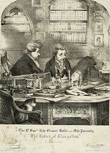 An engraved drawing of two stout Englishwomen sitting in a private library with their hair up in buns and wearing smoking jackets. They are seated at an ornately carved table with various objects on it. A cat sits in the foreground in a chair.