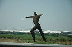Large statue of a human figure with arms outstretched
