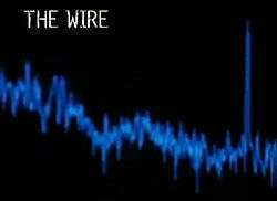 The words "The Wire" in white lettering on a black background. Below it a waveform spectrum in blue.
