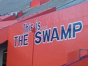 Orange bleacher wall reading, "This is ... THE SWAMP"