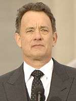 Photo of Tom Hanks standing behind a podium at the Lincoln Memorial in 2009.