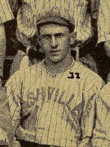 A man wearing a light colored cap and baseball jersey with pinstripes with "Nashville" written across the chest.