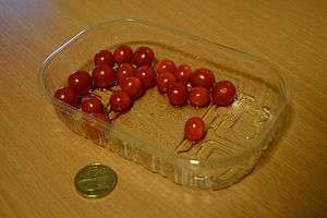 Tomberries next to a British pound coin