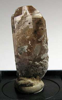 A terminated raw, golden topaz crystal.