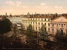 Tinted postcard of long white building