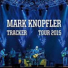 A poster showing Mark Knopfler on stage with his band