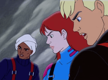 Characters Hadji Singh, Jessie Bannon, and Jonny Quest are shown with faces emphasized in an ice setting. Hadji is very tan-skinned, wearing a turban, navy blue sweater, and red suspenders. Jessie is pale-skinned with red hair and green eyes, and is wearing a blue snow-suit with pink highlights and black suspenders. Jonny has blonde hair and blue eyes, and is lightly tanned; he's wearing a black snow-suit with red suspenders.