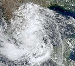 A satellite image of a large, swirling mass of clouds making landfall in Mexico.
