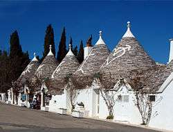Small white houses with conic roofs.