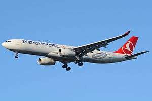 A white and red Turkish Airlines A330-300 with the undercarriages extended over a blue sky.