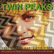 A close-up of a smiling young woman with light skin and hair is overlaid on a picture of a short man wearing a red suit standing on black-and-white chevron floor. The words "Twin Peaks" are placed upon the woman’s forehead in bold green writing, with the words "Angelo Badalamenti and David Lynch" and the word "Music" placed above and beneath "Twin Peaks" in smaller, thinner yellow writing. At the bottom of the cover, the phrases "Season Two Music and More" and "Includes 24 Page Collector’s Picture Book" are printed in the same yellow writing.