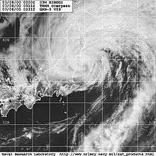 Satellite image of a weakening tropical cyclone, nearly extratropical, just on the coast of eastern Japan. The system has the classic non-tropical comma-shape structure and diminishing clouds cover the center of the storm.