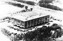 oblique, aerial image in black-and-white of a large, rectangular building