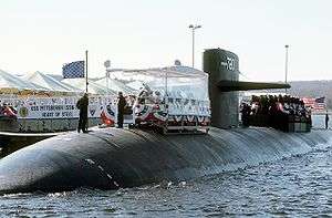 USS Pittsburgh (SSN-720) participates in a dockside ceremony. Note the former USN jack waving from the front of the sub.