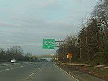 One direction of a multilane highway approaching an exit. A green sign over the road reads south Interstate 287 to Interstate 95 New Jersey Turnpike Perth Amboy with an arrow pointing to the upper right.