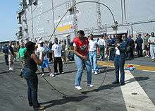 Picture of US service personnel jumping double Dutch on the deck of an aircraft carrier