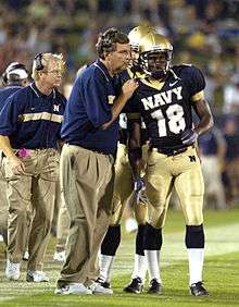 Paul Johnson talks to two of his players during a game