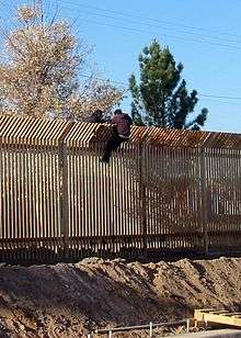 Two men scale the border fence into Mexico near Douglas, Arizona, in 2009