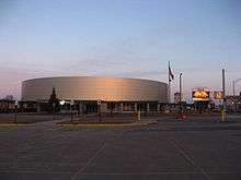 A brightly lit hockey arena, clad in metal panels.