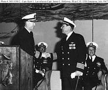 Capt. Kent Lee (left standing) taking command of the USS Enterprise