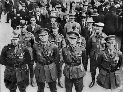 Lines of men in rows of four wearing military uniforms or suits and military medals.