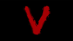 The letter 'V' daubed in red paint on a black background