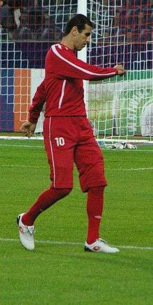 A photograph of a man in red association football attire.