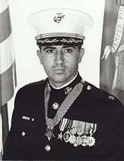 A black-and-white photo of the upper torso of Jay Vargas wearing his military dress uniform with hat and medals