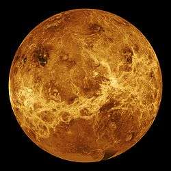 A false-colour image of Venus: ribbons of lighter colour stretch haphazardly across the surface. Plainer areas of more even colouration lie between.