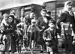 Women and children walking away from boxcars