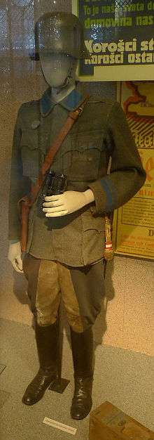 a colour photograph of a glass display case containing a uniform on a mannequin