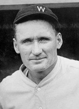 A baseball player is shown from the chest up smiling into the camera.