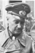 An older man wearing a peaked cap and military coat.
