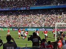 A soccer game between the United States and Canada, seen from behind one of the goals.