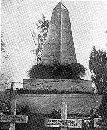 A large stone obelisk memorial surrounded by white cross grave markers. The original caption reads: "A memorial erected by the people of Richon le Zion to the memory of the New Zealanders who fell at Ayun Kara on November 14th, 1917."