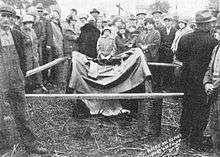 The pushcart or wheelbarrow where Nellie Kehoe's dead body was found (covered by a cloth and surrounded by onlookers) and protected with a crude fence