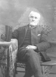 Photo of William Bickerton sitting in a chair.