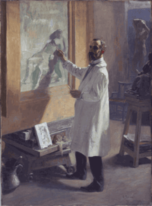 A man wearing a white smock working on a painting