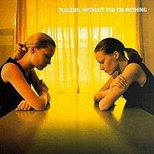 The album cover features two women sitting on a table in front of each other, looking down on the table. The light coming in from the curtains makes a yellow colour on the cover of the album.