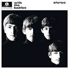 A black-and-white photograph of the Beatles' faces on a black background with the band members wearing black turtleneck sweaters
