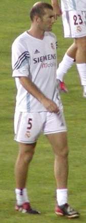 A dark-haired man wearing a white shirt and white shorts with the number "5" displayed on the lower right thigh.