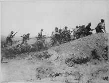 Soldiers advance during an attack over broken ground